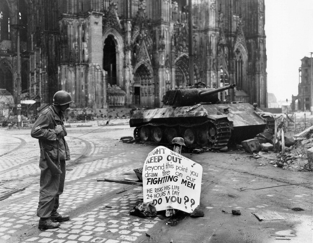 Corporal Luther E. Boger of US 82nd Airborne Division reading a warning sign, Cologne, Germany, 4 April 1945