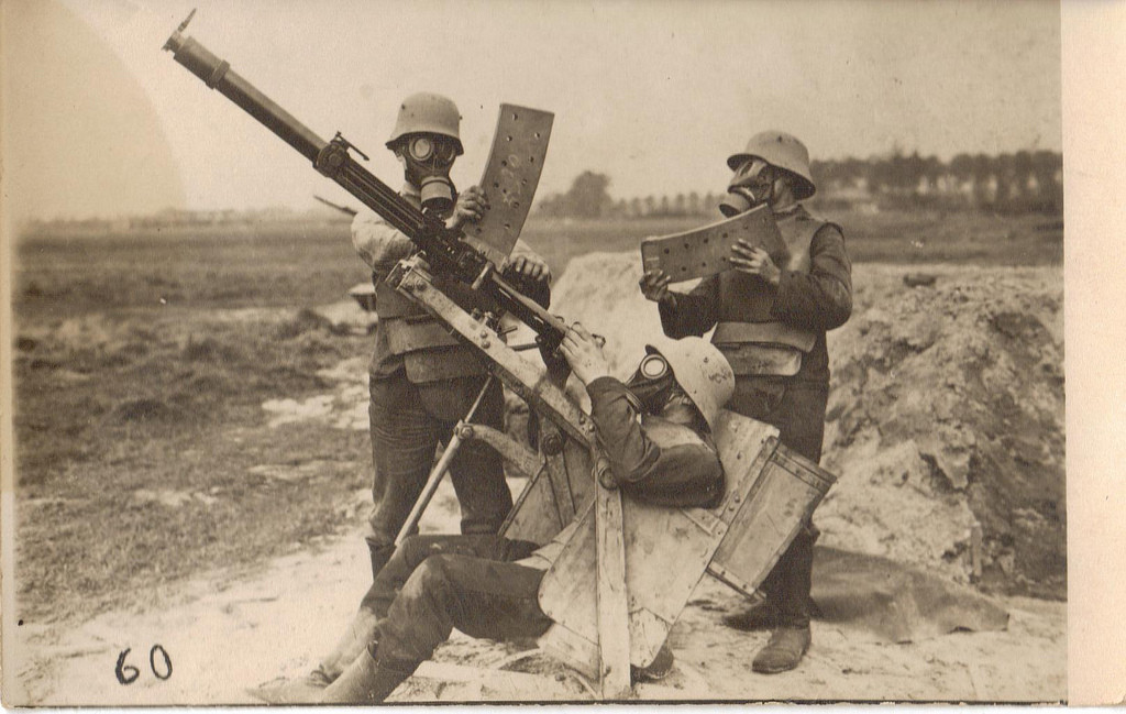 Three German soldiers in body armor and gas masks demonstrate operating a 2cm Becker-Flugzeugkanone, an anti-aircraft gun, Western Front, circa 1918