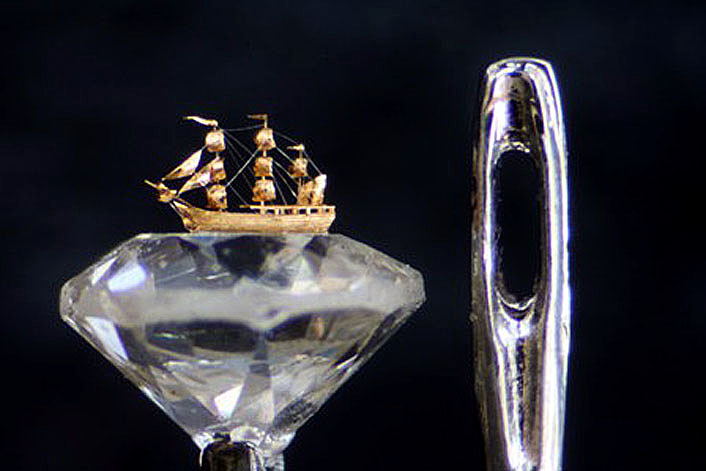 Solid gold clipper ship on a crystal,compared to the size of a needle