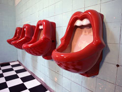 A coalition of 24 organizations, led by The Woman Abuse Working Group, has won a year-long battle with a Canadian eatery to have the urinals shaped like a womans open mouth removed from its mens bathroom. The group was concerned about womens safety and the message it sent to men in the bar. 
