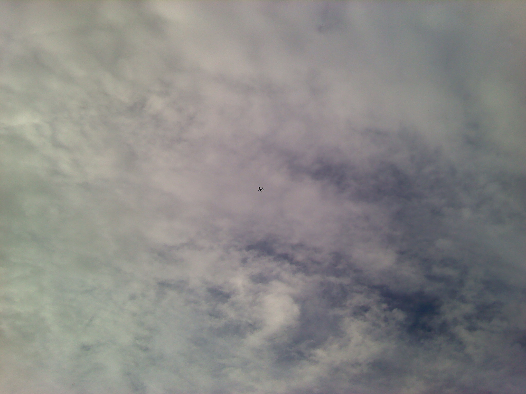 The Clouds are Up Higher in the sky and the Air Plane is Flying Below the Clouds here in Sydney Nova Scotia.