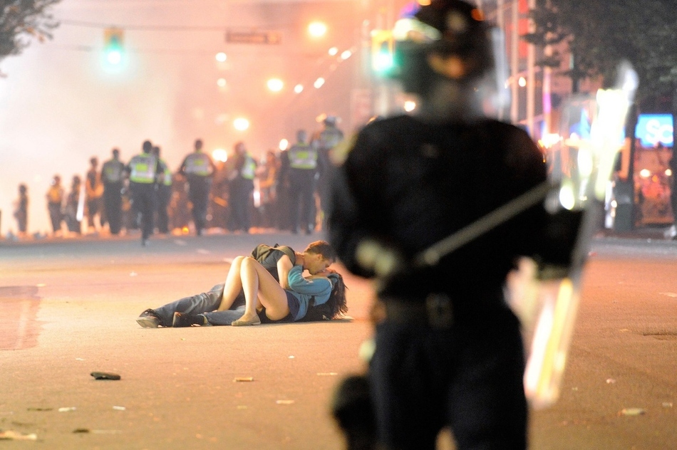 Australian Scott Jones kisses his Canadian girlfriend Alex Thomas after she was knocked to the ground by a police officer's riot shield in Vancouver, British Columbia