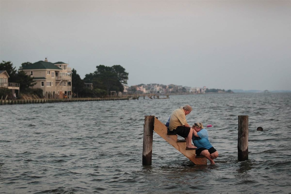 Billy Stinson comforts his daughter Erin Stinson as they sit on the steps where their cottage once stood . Built in 1903, It was destroyed by Hurricane Irene