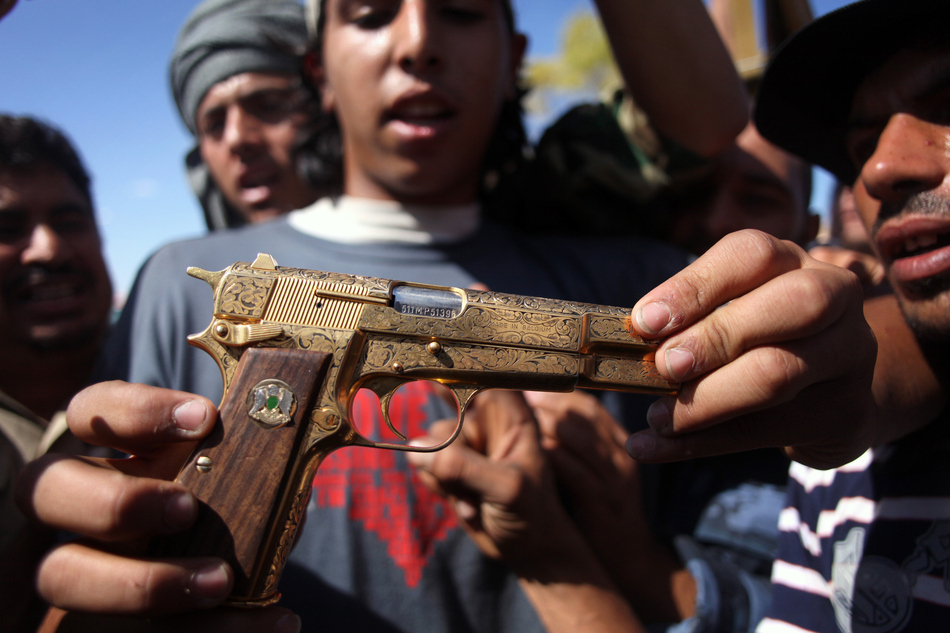A Libyan rebel is pictured with Gadhafi's golden gun.