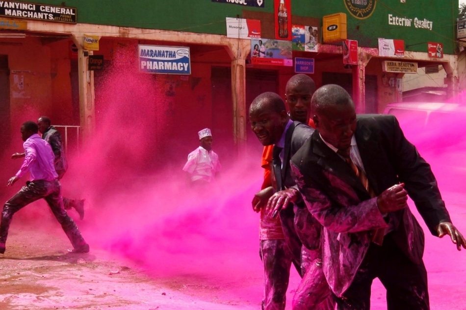 Protesters in Uganda are sprayed with paint.