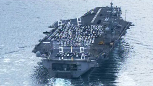 The cars on deck of USS Ronald Reagan gives the viewer an idea as to the size of the enormous ship