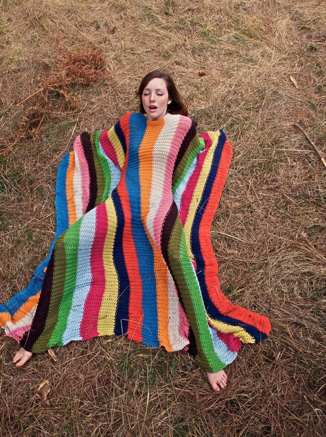 Chick posing under striped blanket