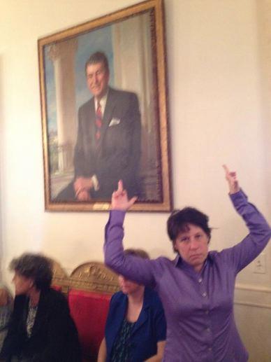 Butch chick flipping off portrait of Ronald Reagan In The White House during LGBT dinner. Stay Classy
