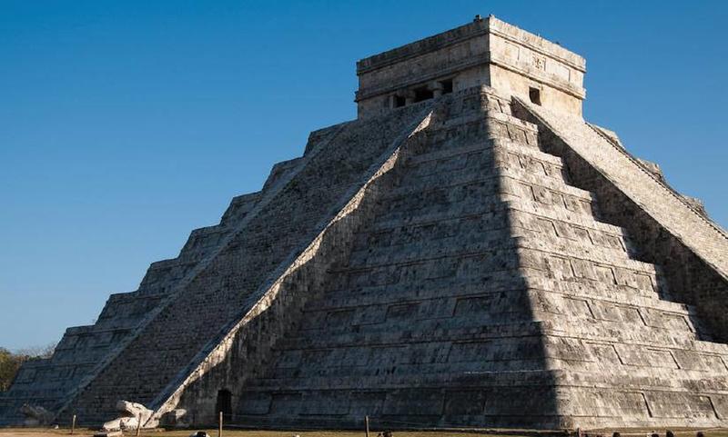 Spring Equinox at the Chichen Itza Kukulcan Temple in Mexico. The sun's rays falling on the Mayan pyramid create a shadow in the shape of a serpent to eventually join a stone serpent head at the base of the great staircase up the pyramid's side