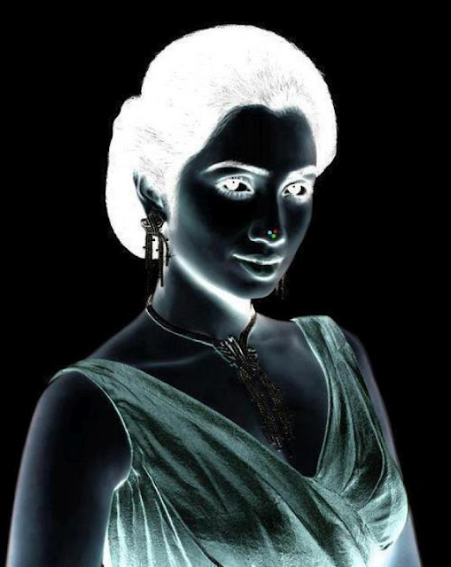 Look a the red point at the end of the nose for 30 seconds. Then look toward your ceiling blinking you eyes.  You will see the original women's image.
