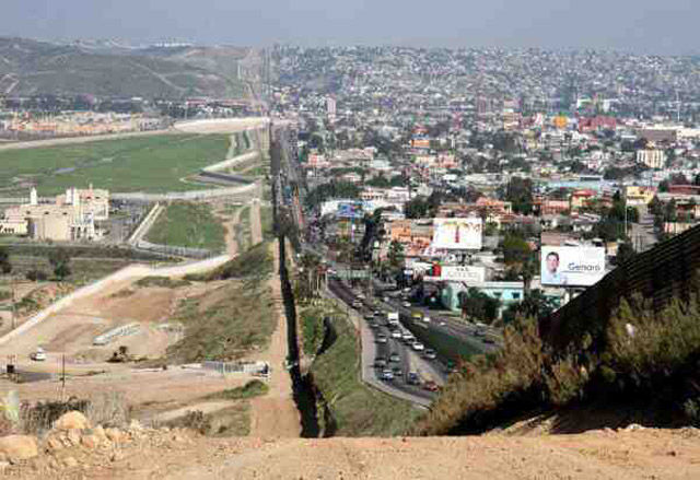 Left side: San Diego, California, right side Tijuana Mexico.  The building on the left side is the sewer treatment plant for the Tijuana river