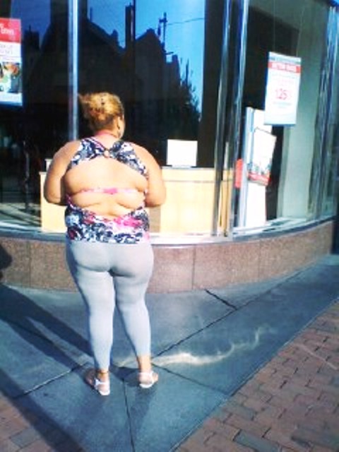 This is why fat people should not wear tights as pants and an open back top.