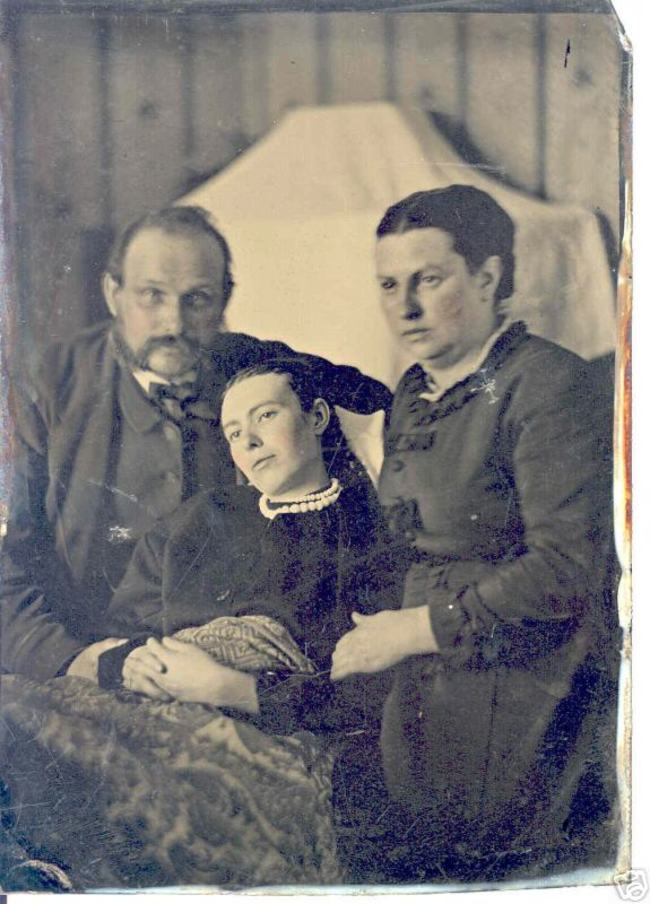 Two parents posed with their dead daughter in the middle.