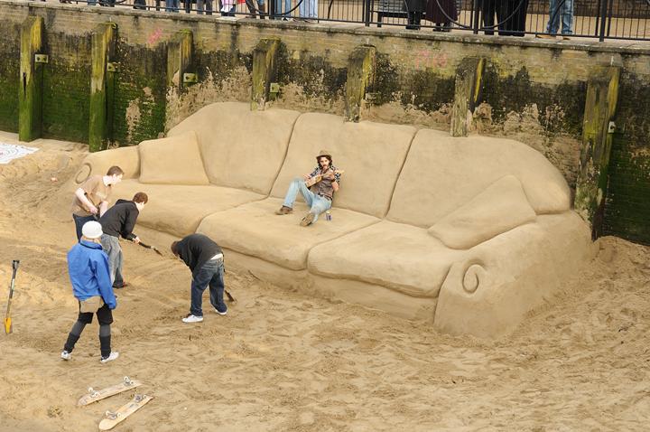 Kids build a massive couch out of sand. I wouldn't mind chillin on it with a Corona.