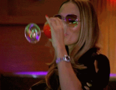 gifs - woman breathes out smoke from cocktail through her nose