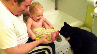 Caturday gif of a cat licking a baby's feet