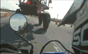 motorcycle going under farm vehicle