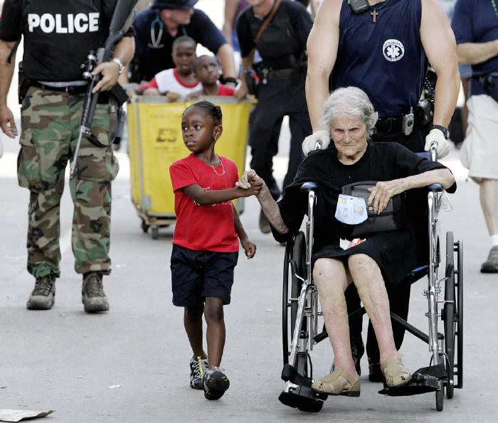 Five year-old Tanisha Blevin holds the hand of fellow Hurricane Katrina victim, one hundred five year-old Nita LaGarde as they are evacuated from the convention center in New Orleans.