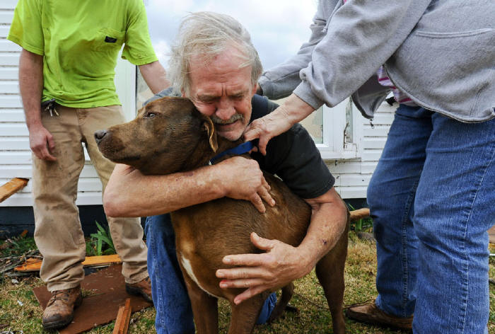 Greg Cook hugs his dog Coco after finding her inside his destroyed home in Alabama following the Tornado in March, 2012.