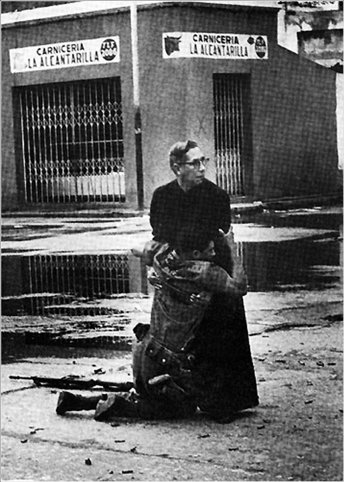 Navy chaplain Luis Padillo gives last rites to a soldier wounded by sniper fire during a revolt in Venezuela.