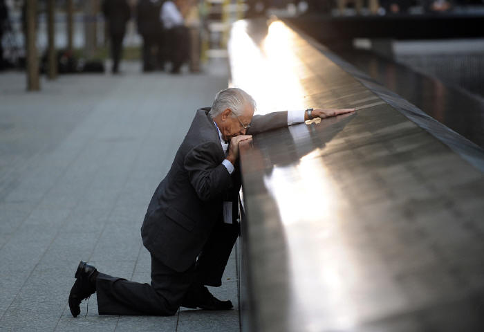 Robert Peraza pauses at his son's name on the 911 Memorial during the tenth anniversary ceremonies at the site of the World Trade Center