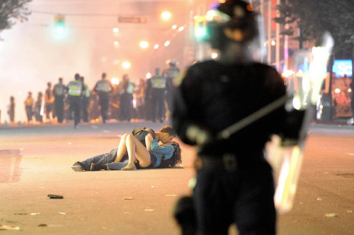 Australian Scott Jones kisses his Canadian girlfriend Alex Thomas after she was knocked to the ground by a police officer's riot shield in Vancouver, British Columbia.