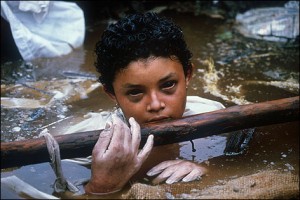 One of the 25,000 victims of the Nevado del Ruiz Colombia volcano which erupted on November 14, 1985.The 13-year old had been trapped in water and concrete for 3 days, and this photo was taken shortly before she died. Her eyes probably are so dark because of internal bleeding..