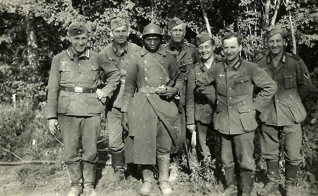 Germans posing with a French prisoner of war. France, 1940.