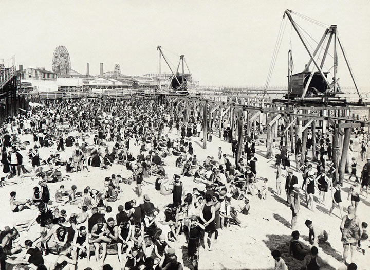 Coney Island looking east from Steeplechase Pier showing Sunday bathers, crowd on beach, on July 30, 1922.