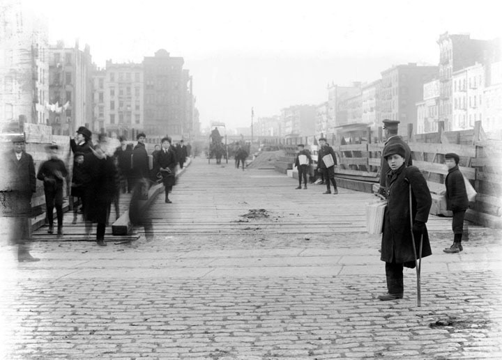 A one-legged newspaper boy and other "newsies", on Delancey Street, on December 26, 1906.