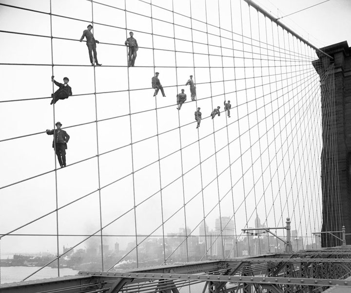Painters suspended on cables of the the Brooklyn Bridge, on October 7, 1914.