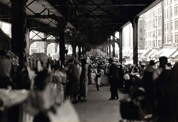 A crowded street market under New York City Rail Road tracks, looking south on Park Avenue from 123rd Street in June of 1932.
