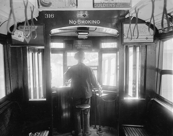 A motorman operates a trolley cars near Williamsburg Bridge, on September 25, 1924. Signs advertise almonds, cold remedies, mustard, and stove polish.   thanks for viewing.