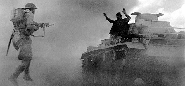 A Panzer III tank crewman surrenders to an advancing British soldier during the Battle of El Alamein, 1942.