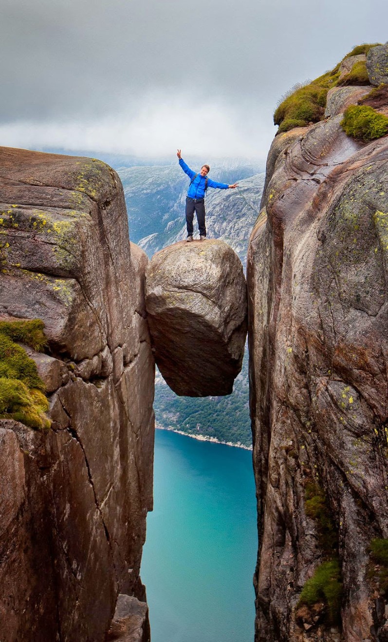 3.  Kjeragbolten, Rogaland, Norway A man daringly stands atop Kjeragbolten, a boulder wedged in a mountain crevice thats suspended above a 3,228-foot deep abyss.