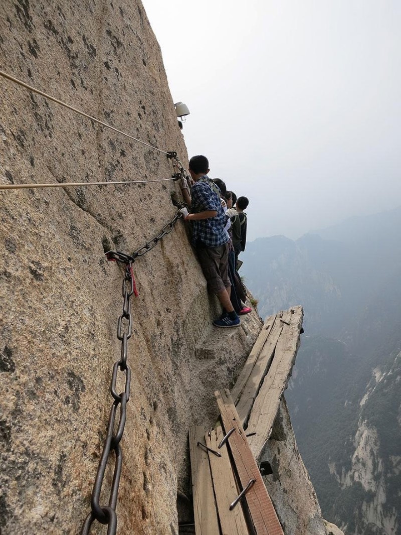 7. Mt. Huashan Hiking Trail, China An adventurous group walk along the infamous plank path of the Mt. Huashan Hiking Trail.