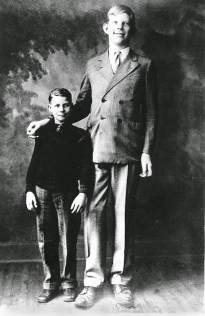 When he started walking at the age of 11 months he was already 3' 5 and weighed 40 pounds - roughly the same height and weight as most 4 year olds.Robert standing next to a classmate at the age of 10. At 6' 6 he towered over all the kids and 99 of adults.