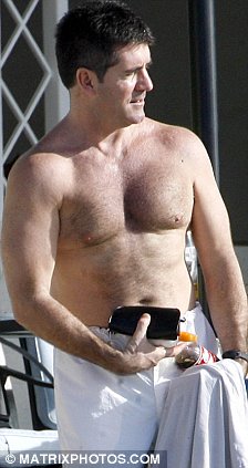 200 push ups a day, a diet , and vitamins has eliminated his man boobs and turned Simon Cowell into what we call in the gay world a Daddy. Showing off his new buff bod at the ultra exclusive five-star Sandy Lane resort in Barbados for the Christmas and New Year period, Simons living it up for the mandatory 14 night stay.

