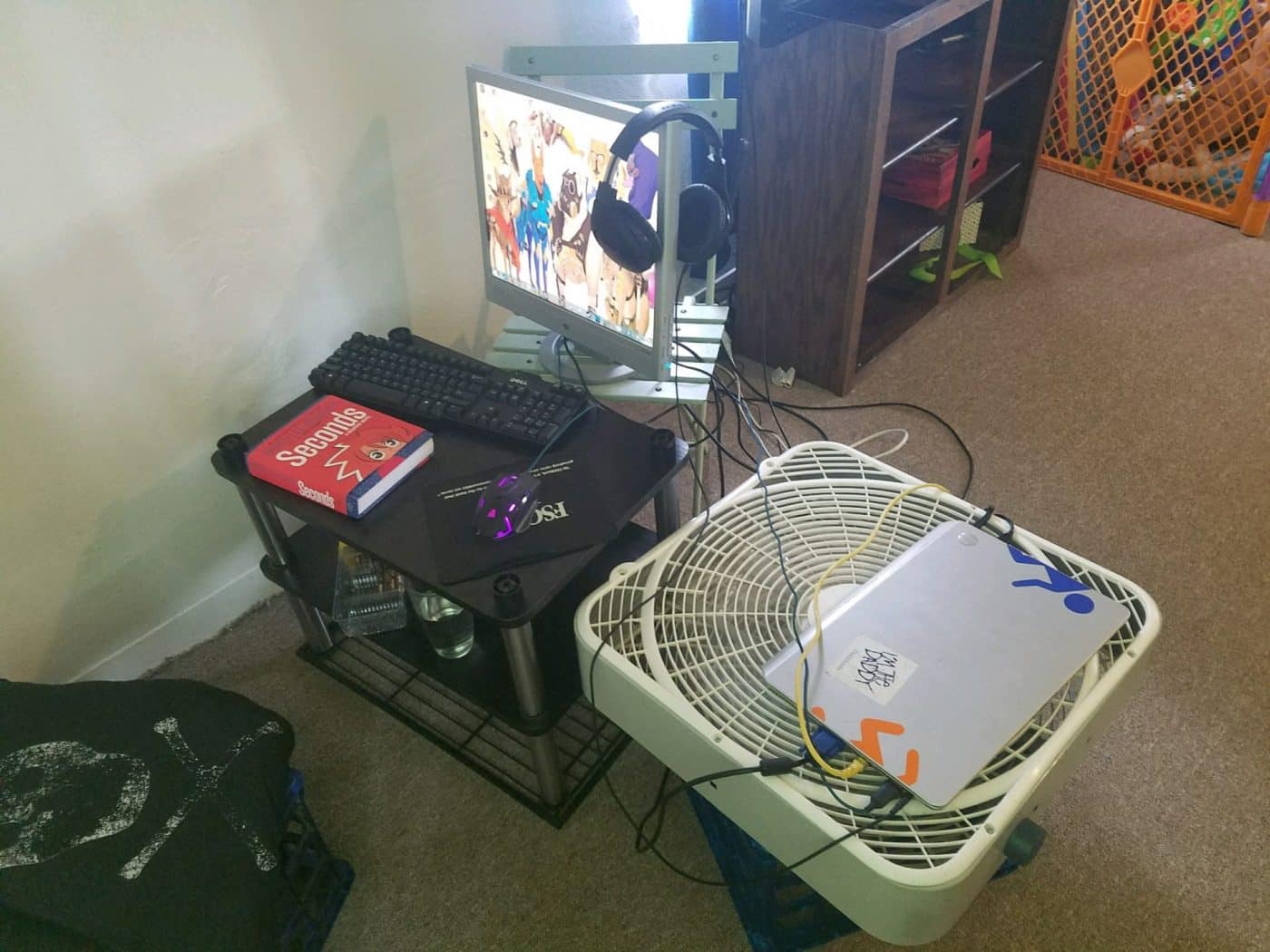 With a box fan air cooling setup, tiny monitor, keyboard on a small table, and and uncomfortable chair with no support, this gamer is headed for the "my back hurts" hall of fame.