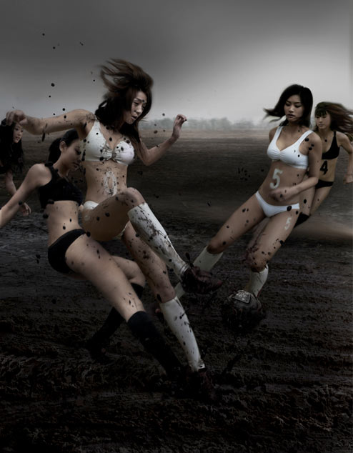 Asian girls playing soccer in the mud