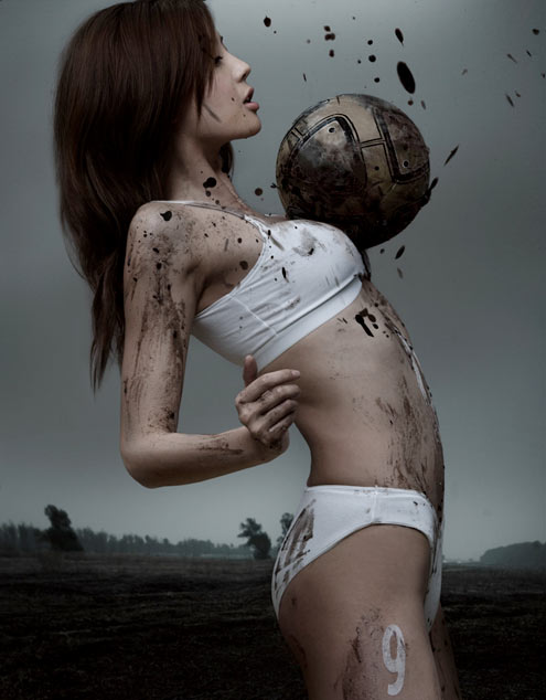 Asian girls playing soccer in the mud