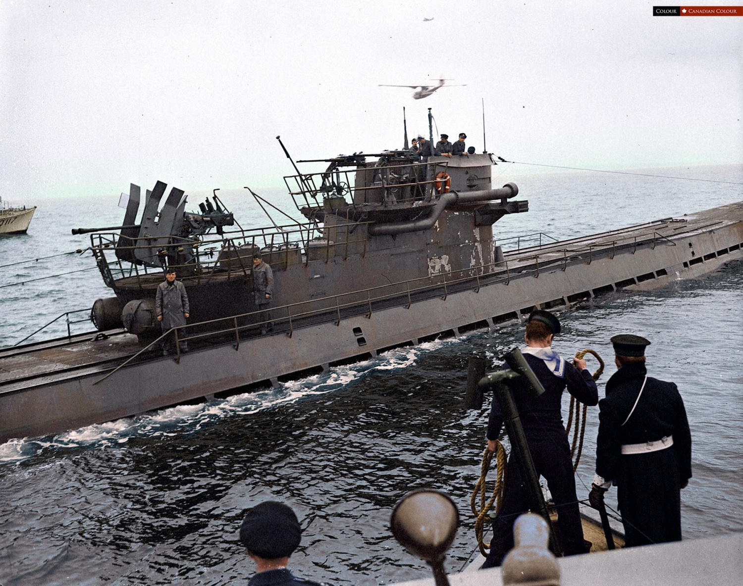 Colorized photo of a German U-889 surrendering to a Canadian built Fairmile Q-117 off Shelburne Nova Scotia May, 1945