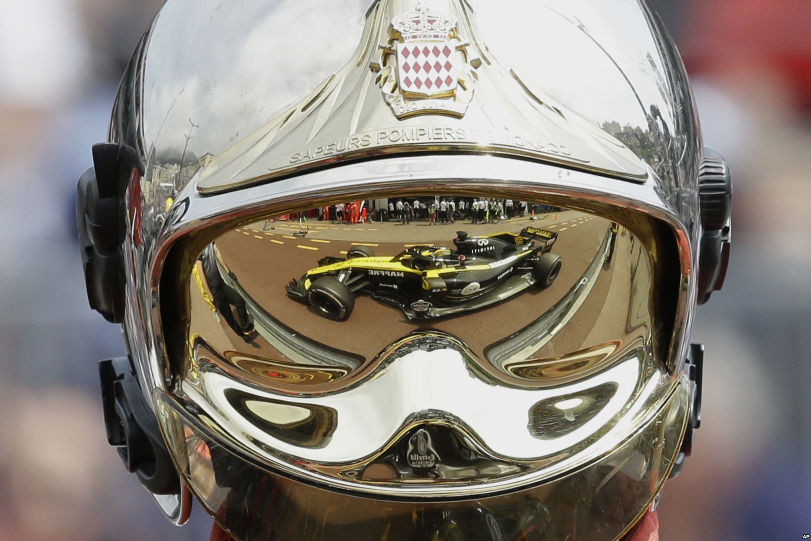 Renault driver Nico Hulkenberg's car reflected in a fireman's helmet at the Monaco Formula One Grand Prix (AP photo)