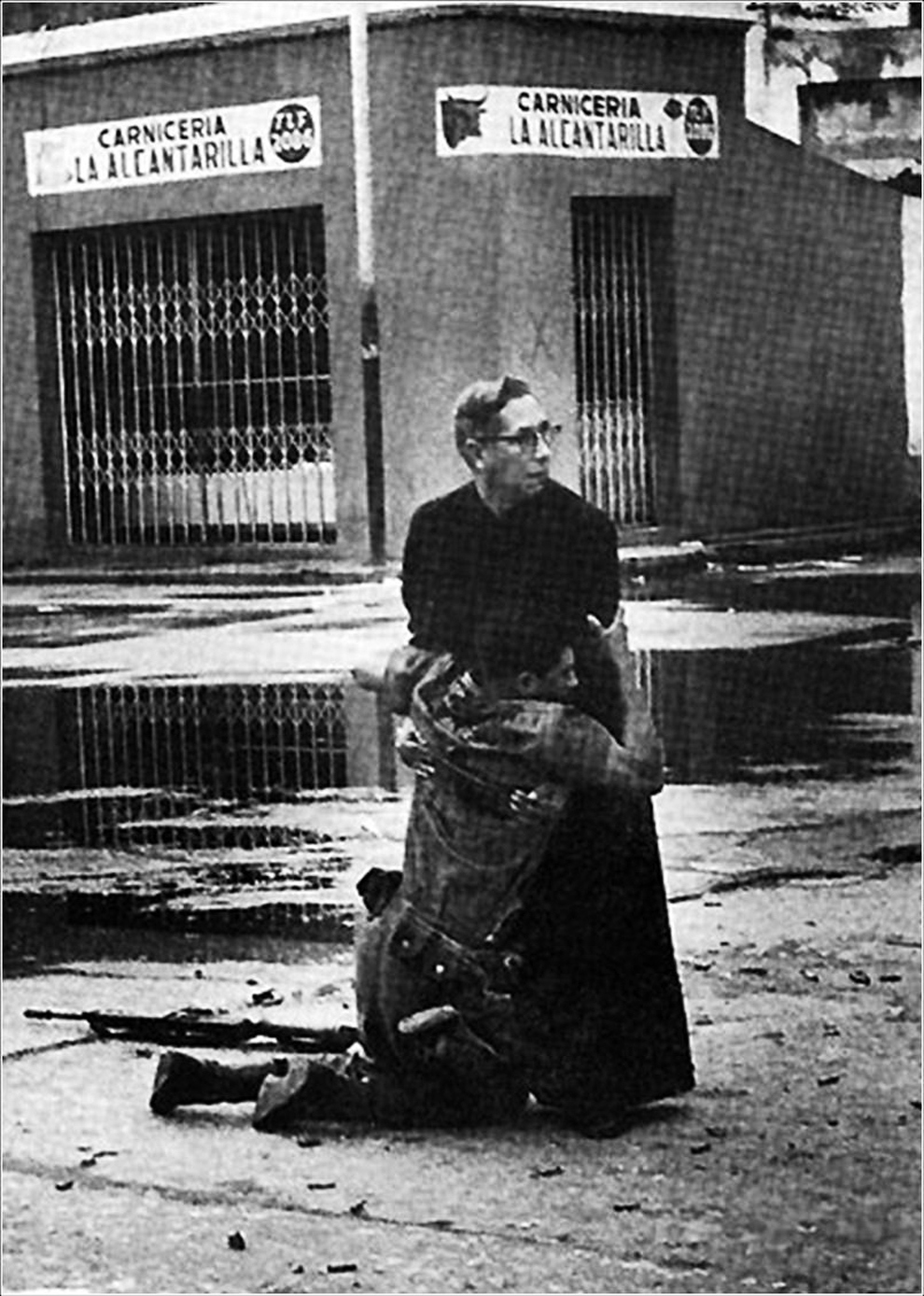 Navy chaplain Luis Padillo gives last rites to a soldier wounded by sniper fire during a revolt in Venezuela