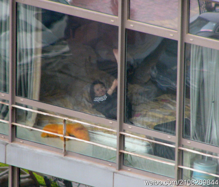 Nude Chinese woman sunbathing in the window