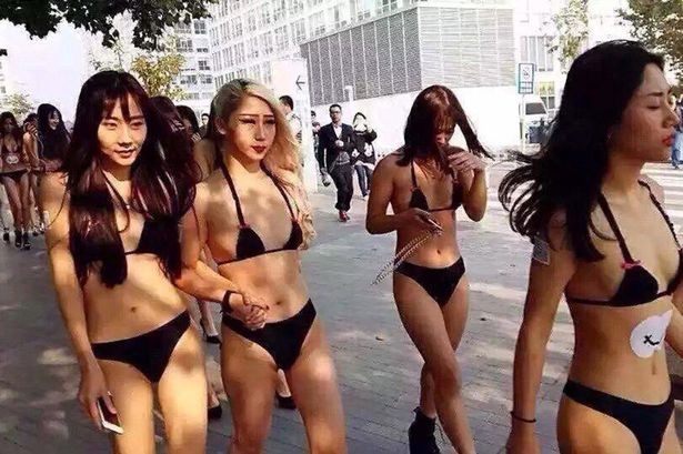 Bikini wearing Beijing girls with barcodes on their butts.