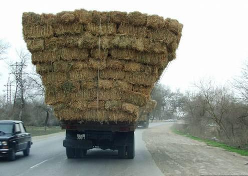 funny picture of a truck over loaded with way too much hay
