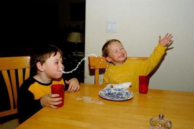 This kid launches nearly a whole glass of milk across the table!