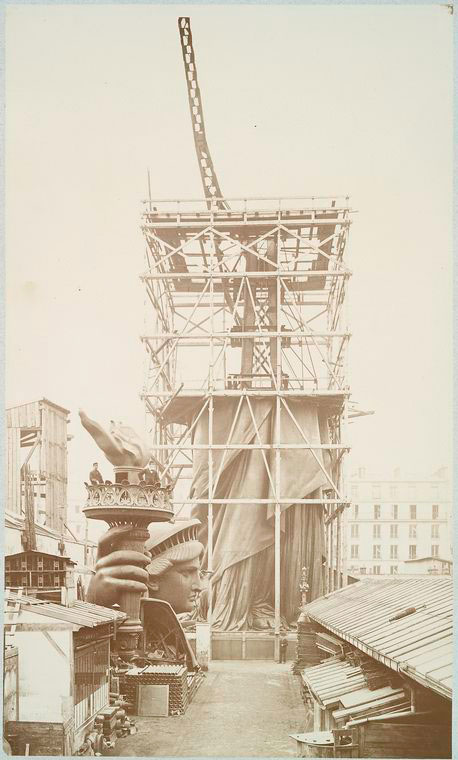 Assemblage of the Statue of Liberty in Paris, with the bottom half of the statue erect under scaffolding