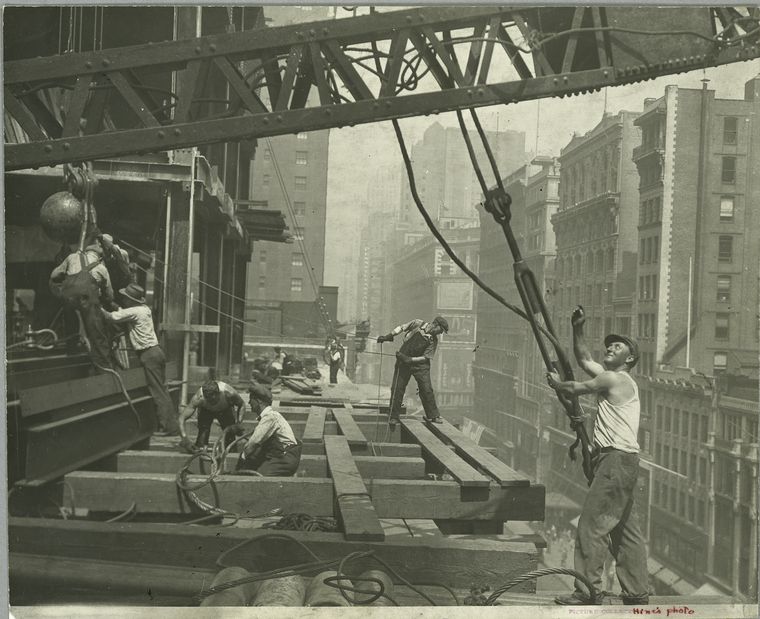 Workers guiding hoisting cable